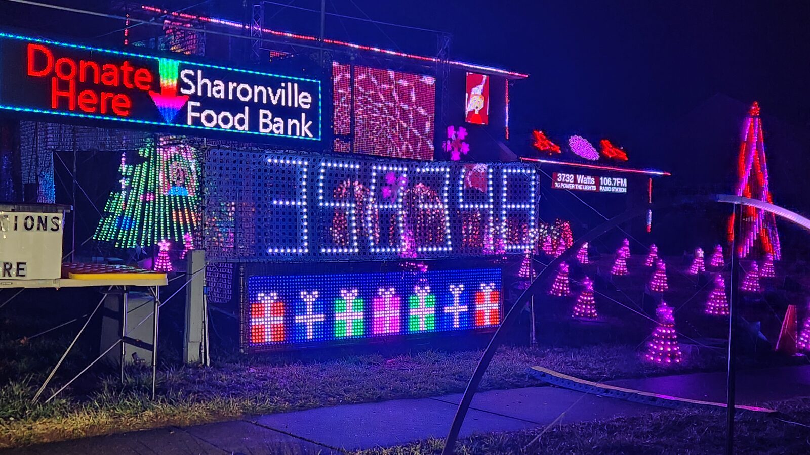The lit Donate Here — Sharonville Food Bank sign above the car counter at the display