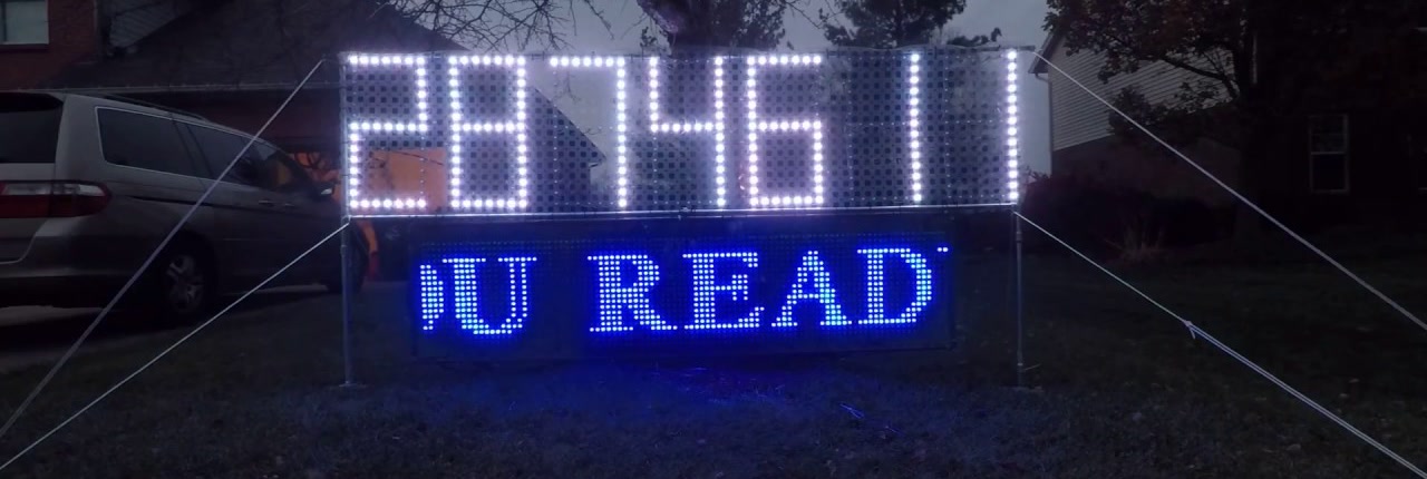 The pixel countdown clock at dusk showing 2874611 seconds, with the grid below scrolling a message in blue